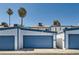 Exterior shot of garages with blue doors and landscaping, creating a clean aesthetic at 4259 Kona Coast Way, Las Vegas, NV 89121