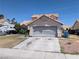 View of home featuring two-car garage, desert landscaping, and tile roof at 5004 Deep Forest Dr, Las Vegas, NV 89130
