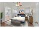 Bright bedroom featuring wood floors, ceiling fan, and ensuite bathroom with soaking tub at 5517 Meridian Rain St, North Las Vegas, NV 89031