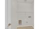 A clean, tiled laundry room with a shelf and utility hookups at 5517 Meridian Rain St, North Las Vegas, NV 89031