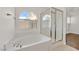 Main bathroom with soaking tub, glass shower, and a window at 5517 Meridian Rain St, North Las Vegas, NV 89031