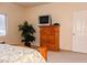 Bright bedroom features wood furniture and a decorative palm tree at 5845 Swan Point Pl, Las Vegas, NV 89122