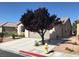 A side view of a house showing the driveway, garage, landscaping and a tree in the front yard at 5845 Swan Point Pl, Las Vegas, NV 89122