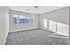 Bedroom featuring plush gray carpet, and large windows with neighborhood views at 600 Baysville Ct, Las Vegas, NV 89144