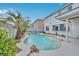 Backyard with a freeform pool, surrounded by lush landscaping and a patio area at 600 Baysville Ct, Las Vegas, NV 89144