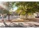 Street view of a quaint home with a white picket fence and mature trees offering shade at 620 Avenue H, Boulder City, NV 89005
