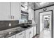 Updated kitchen with stainless steel appliances, white cabinets, granite countertops, and gray backsplash at 620 Avenue H, Boulder City, NV 89005