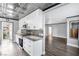 Modern kitchen featuring white cabinets, stainless steel appliances, and granite countertops overlooking living area at 620 Avenue H, Boulder City, NV 89005