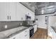 Modern kitchen featuring white cabinets, stainless steel appliances, and granite countertops at 620 Avenue H, Boulder City, NV 89005