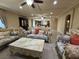 Open-concept living space with luxurious sofas, tile flooring, and a seamless flow into the kitchen at 6277 Mustang Spring Ave, Las Vegas, NV 89139