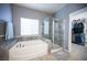 Bright bathroom featuring a glass enclosed shower and separate tub next to the walk-in closet at 6333 Sterling Ranch Way, North Las Vegas, NV 89081