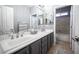 Modern bathroom featuring dual sinks, gray cabinetry, tile floors, and a separate bathtub at 6333 Sterling Ranch Way, North Las Vegas, NV 89081