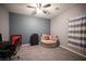 Comfortable bedroom with a cozy armchair, modern ceiling fan, and neutral decor, creating a relaxing atmosphere at 6333 Sterling Ranch Way, North Las Vegas, NV 89081