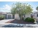 Cozy home with a two-car garage, desert-style landscaping, and shade trees on a sunny street at 6333 Sterling Ranch Way, North Las Vegas, NV 89081