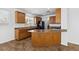 A kitchen with an island, brown cabinets, and tile flooring at 6636 Surfbird St, North Las Vegas, NV 89084