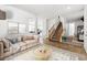 Bright living room with neutral tones, tile flooring, staircase, and comfortable seating arrangement at 6636 Surfbird St, North Las Vegas, NV 89084