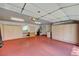 Spacious garage featuring cabinets and red painted flooring at 6944 Emerald Springs Ln, Las Vegas, NV 89113