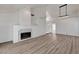 Spacious living area featuring wood-look floors, fireplace, and a modern chandelier at 6944 Emerald Springs Ln, Las Vegas, NV 89113