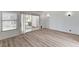 Bright living room featuring wood floors, neutral paint, large windows, and a sliding glass door at 6944 Emerald Springs Ln, Las Vegas, NV 89113