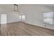 Bright, open living room featuring stylish wood flooring and abundant natural light from large windows at 6944 Emerald Springs Ln, Las Vegas, NV 89113