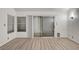 Spacious living room with wood floors, modern lighting, and a sliding glass door leading to the patio at 6944 Emerald Springs Ln, Las Vegas, NV 89113