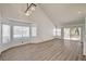 Bright living room featuring wood floors, high ceilings, a modern chandelier, and large windows providing ample natural light at 6944 Emerald Springs Ln, Las Vegas, NV 89113