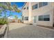 View of gravel backyard and stucco home, with back door access at 7528 Golden Yucca Dr, Las Vegas, NV 89147