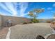 Gravel backyard featuring a grill and a bench on a sunny day at 7528 Golden Yucca Dr, Las Vegas, NV 89147
