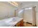 Bright bathroom features a large mirror, oak cabinets, and a shower with a curtain at 7528 Golden Yucca Dr, Las Vegas, NV 89147