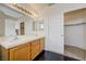 Bathroom featuring double sinks, wood cabinets and an adjacent walk-in closet at 7528 Golden Yucca Dr, Las Vegas, NV 89147
