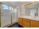 Bright bathroom featuring a double sink vanity, and a walk-in shower with glass doors at 7528 Golden Yucca Dr, Las Vegas, NV 89147