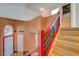 View of the red staircase leading to the second floor of the home and open concept design at 7528 Golden Yucca Dr, Las Vegas, NV 89147