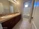 Bathroom with double sinks, tile countertops, tile floor, and bathtub with tile surround at 7609 Slide Rock Ave, Las Vegas, NV 89113