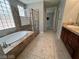Bathroom features a walk-in shower and soaking tub with natural light at 7609 Slide Rock Ave, Las Vegas, NV 89113