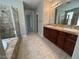 Bathroom featuring double vanity, walk-in shower, and soaking tub at 7609 Slide Rock Ave, Las Vegas, NV 89113