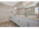 Bright bathroom with double sinks, a large mirror, and a glass-enclosed shower for a spa-like experience at 7736 Tioga Ridge Ct, Las Vegas, NV 89117