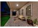 Spacious covered patio with outdoor seating, offering a serene view of the landscaped backyard and illuminated pool at 7736 Tioga Ridge Ct, Las Vegas, NV 89117