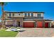 Contemporary two-story home featuring stone accents, a three-car garage and desert landscaping at 7736 Tioga Ridge Ct, Las Vegas, NV 89117
