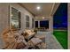 Relaxing outdoor living space with comfortable seating, overlooking a lush lawn and an inviting, lit pool area at 7736 Tioga Ridge Ct, Las Vegas, NV 89117