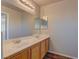 Bathroom featuring a dual sink vanity with wood cabinets and a large mirror at 7919 Dexter Falls St, Las Vegas, NV 89149