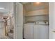 Brightly lit laundry room with washer and dryer, shelving, and folding doors at 7919 Dexter Falls St, Las Vegas, NV 89149