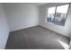 A cozy bedroom with neutral carpet, white walls, and a window offering natural light at 8020 Texas Hills St, Las Vegas, NV 89113