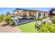 Serene backyard featuring a pool, outdoor kitchen, covered patio, and lush landscaping, perfect for entertaining at 8298 W Agate Ave, Las Vegas, NV 89113