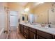 Bathroom with dual sinks, tile floors, a large mirror, and bright vanity lights at 8298 W Agate Ave, Las Vegas, NV 89113