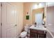 Well-lit half bathroom featuring a single sink vanity, toilet, and neutral wall color at 8298 W Agate Ave, Las Vegas, NV 89113
