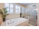 Serene bathroom featuring a soaking tub and glass-enclosed shower with neutral color palette at 8298 W Agate Ave, Las Vegas, NV 89113