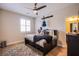 Cozy bedroom with wood-look floors, ceiling fan, blue guitar, and plush rug at 8298 W Agate Ave, Las Vegas, NV 89113