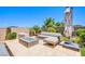 Relaxing outdoor lounge area with a modern fire pit, comfortable seating, and lush landscaping at 8298 W Agate Ave, Las Vegas, NV 89113