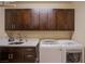 Laundry room with upper cabinets, modern washer and dryer, and a sink at 8298 W Agate Ave, Las Vegas, NV 89113