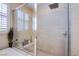 Luxurious glass shower featuring tile surround and modern fixtures, next to soaking tub and windows at 8298 W Agate Ave, Las Vegas, NV 89113